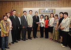 佐藤総務相（中央）に要望書を手渡す西岡会長（右隣）ら＝１３日　総務省