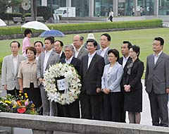 原爆死没者慰霊碑に献花する桝屋氏（前列中央）ら＝２９日　広島市