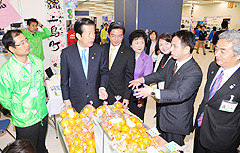 島の特産品を見て回る山口代表（左から3人目）ら＝26日　都内