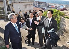 町内会長の案内で災害時の避難経路の課題などを調査する（右から）遠山、伊藤、山本（博）の各氏ら＝27日　三重・鳥羽市の神島